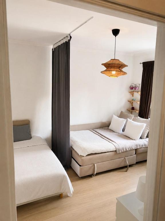 a bedroom with two beds and a chandelier at Mysig lägenhet i centrum in Västerås