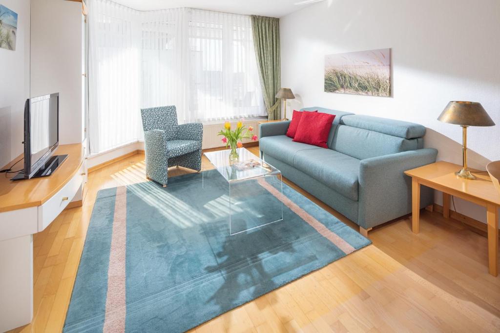 a living room with a couch and a television at Kleine Möwe 08 in Norderney