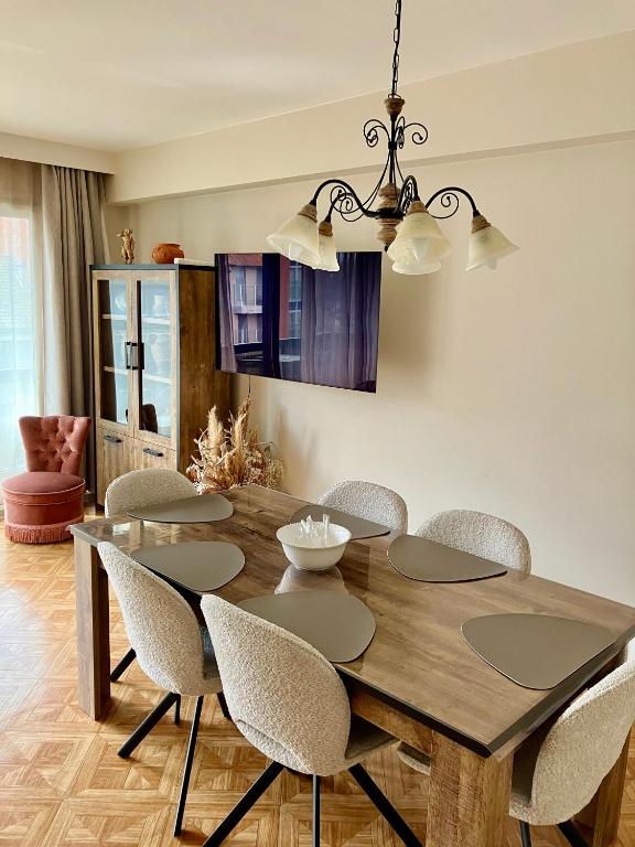 a dining room with a wooden table and chairs at Sunshine centrum in Koksijde