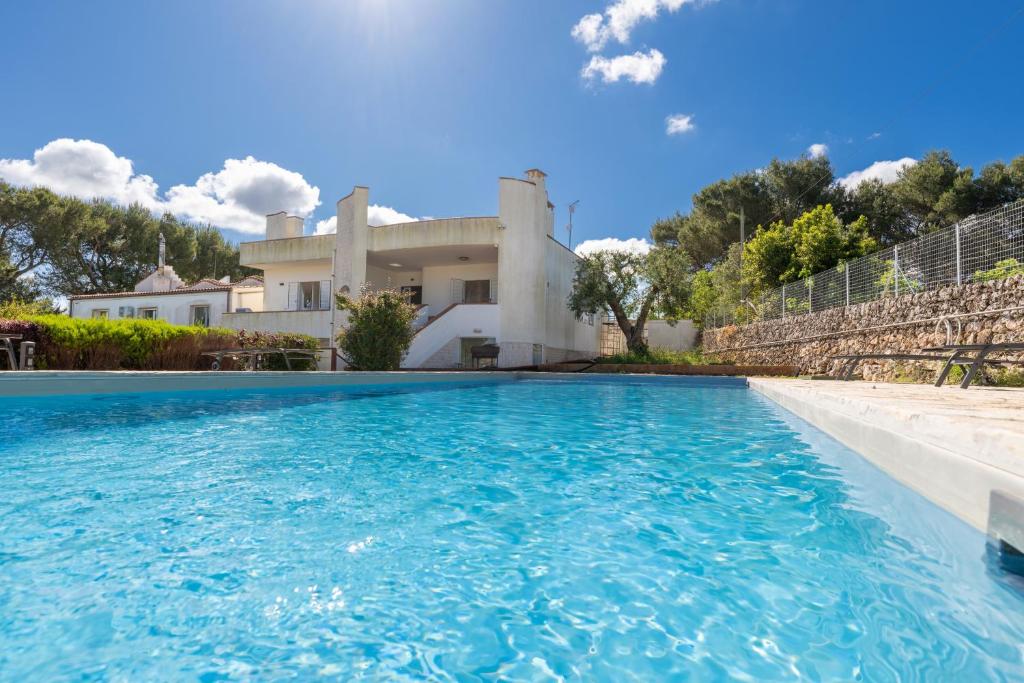 a villa with a swimming pool in front of a house at Villa Montevicoli in Ceglie Messapica