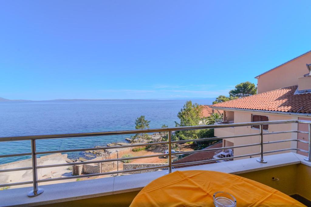 an orange tent on a balcony overlooking the water at La porta sul Mare - Apartment Punta in Veli Lošinj