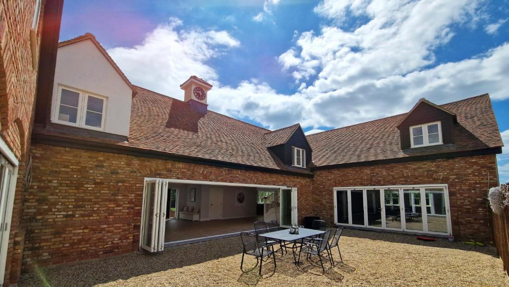 a brick house with a table in the courtyard at The Clock House in Sacomb
