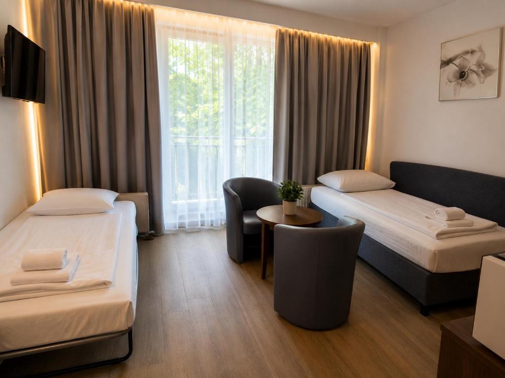 a hotel room with two beds and a window at Alpine Studio near Bad Ischl in Bad Ischl