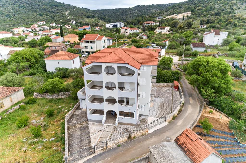 an aerial view of a white building with an orange roof at Dzon Beachside Apartments in Vinišće