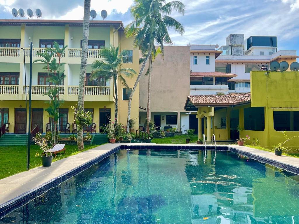 a swimming pool in front of a building at Muthukirula Resort in Aluthgama