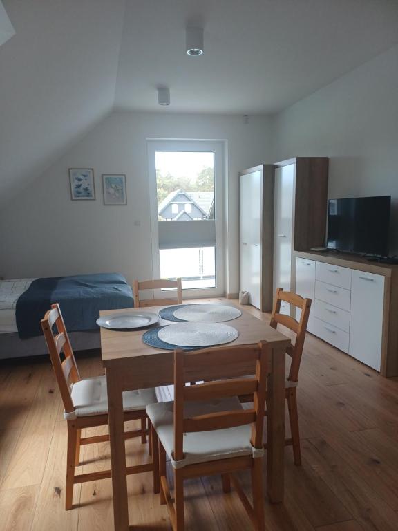 a kitchen and dining room with a table and chairs at APARTAMENTY BAŁTYCKA 4d in Rowy