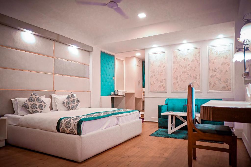 a bedroom with a bed and a table and a desk at Hotel Samrat - A Boutique Hotel in Prayagraj