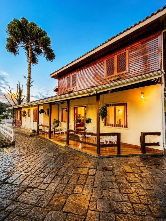 an old building with a tree in the background at Pousada Pinheiro Real in Campos do Jordão