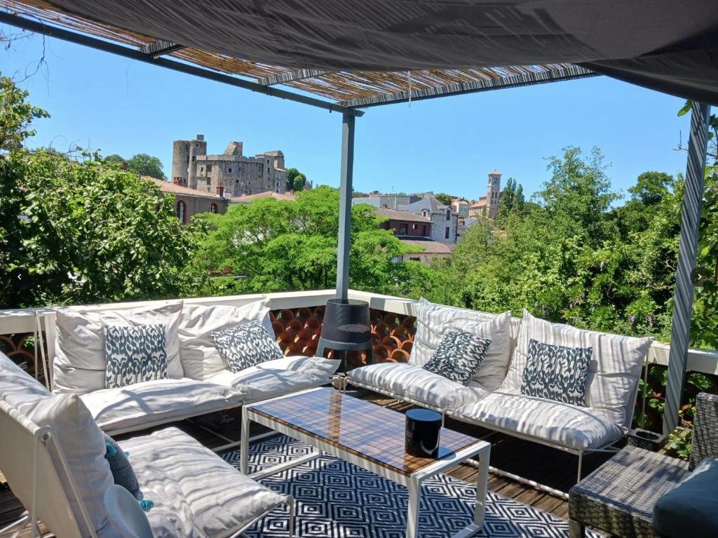a patio with white couches and a table at Maison centre-ville, Vue château, Hellfest, Clisson in Clisson