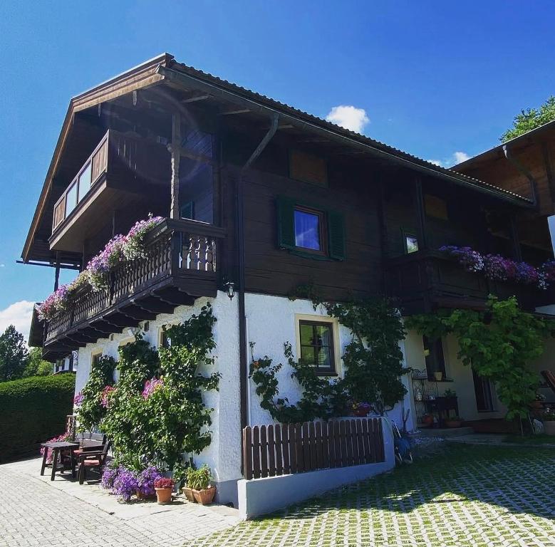 a house with a balcony and flowers on it at Landhaus Aigner in Mittersill