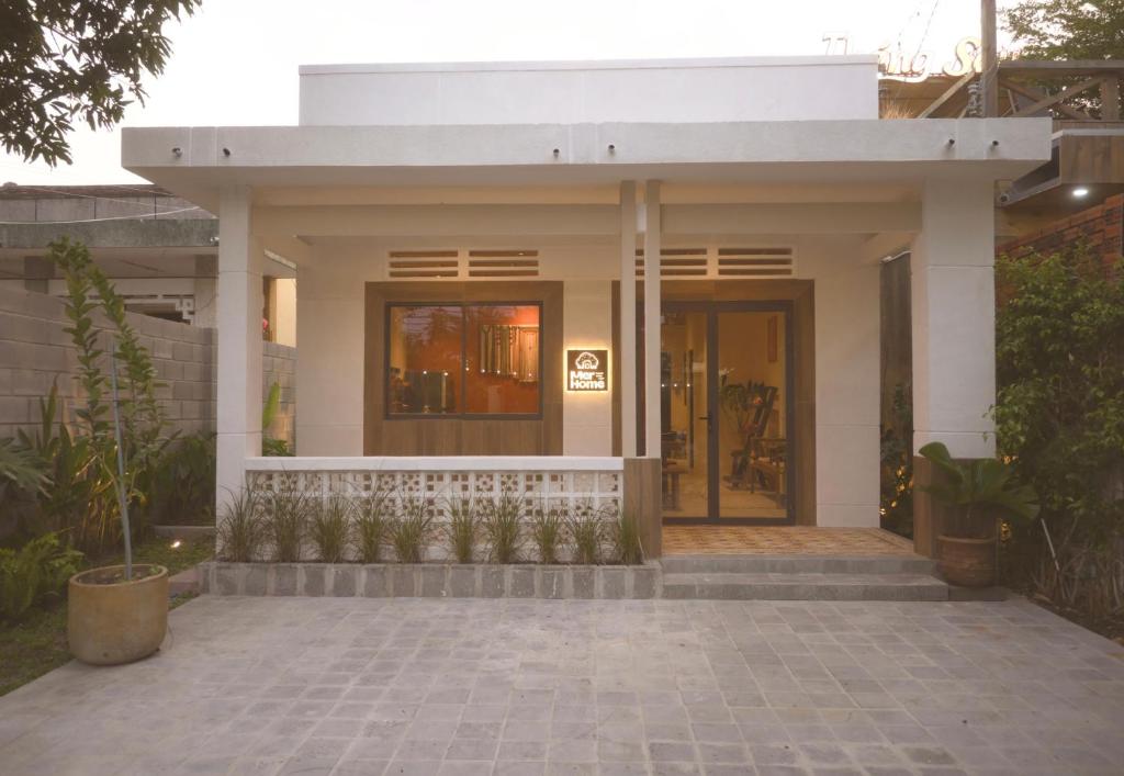 a small white house with a porch and a door at Mer Home in Tây Ninh