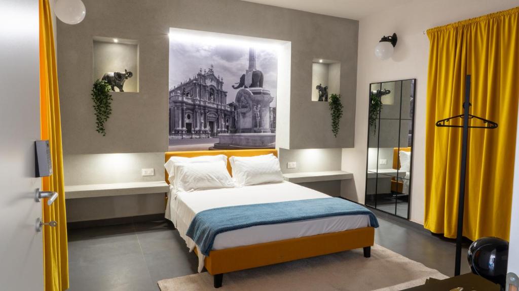 a bedroom with a bed with a painting on the wall at Aetna LuxurySuites in Catania