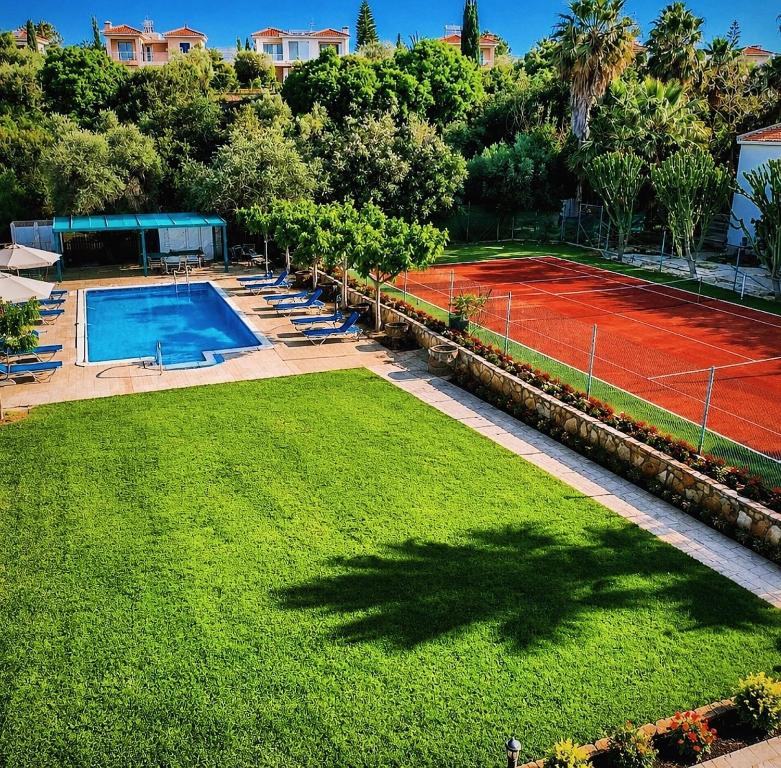 an overhead view of a tennis court with chairs and a tennis court at Amalia Apartments in Polis Chrysochous