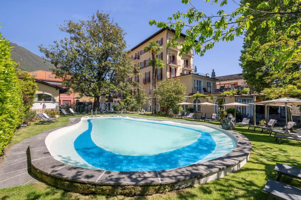 a swimming pool in the yard of a house at Schloss Locarno - Suites & Apartments in Locarno