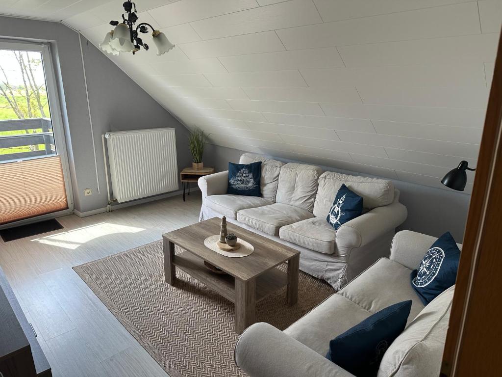 a living room with a couch and a table at Rosenhaus Esens - Wohnung Backbord in Esens
