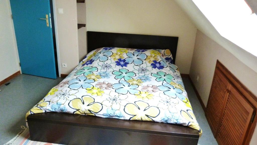 a bedroom with a bed with a floral bedspread at Veigné Room in Veigné