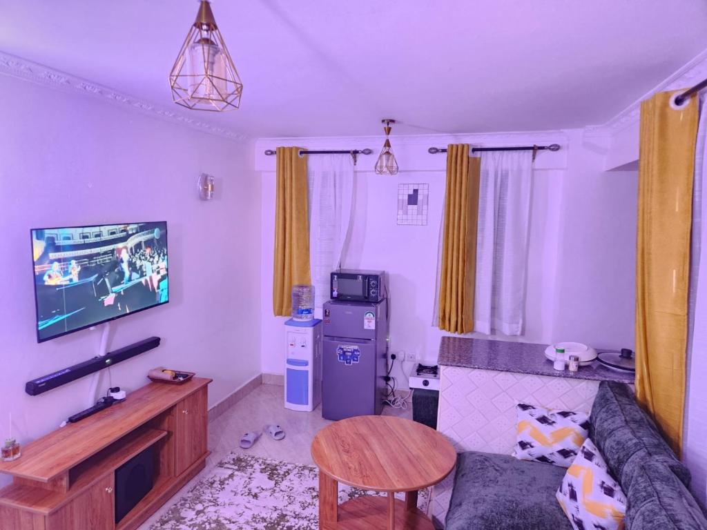 a living room with a couch and a tv at Ansan Comfort in Gatunga