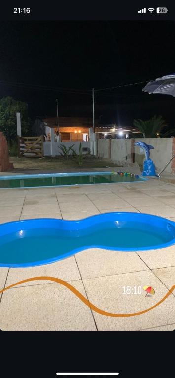 a blue frisbee on the ground near a pool at night at Chácara Marias Da Serra in Araruna