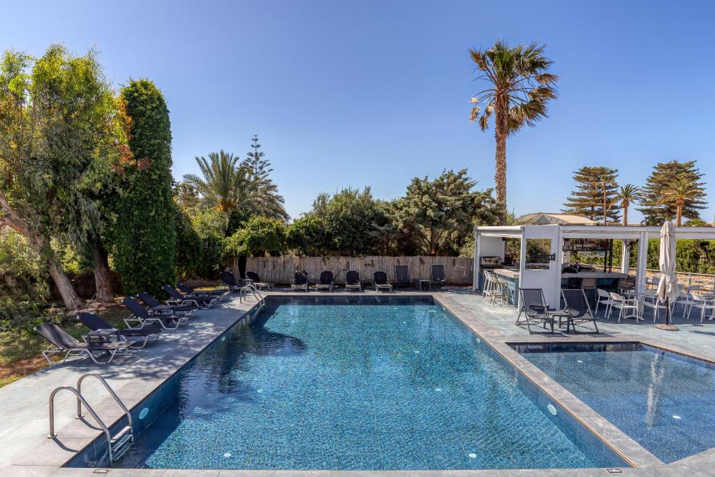 a swimming pool with chairs and a gazebo at Naiades Hotel by Estia in Kato Gouves