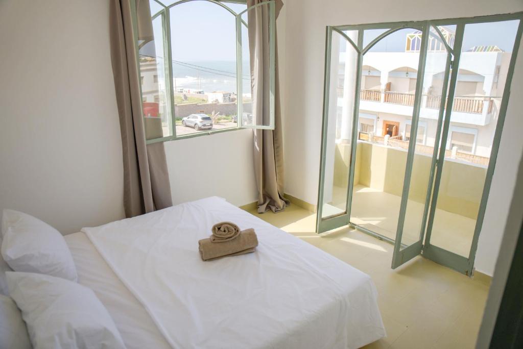 a ring on a bed in a room with a window at Sand House in Imsouane
