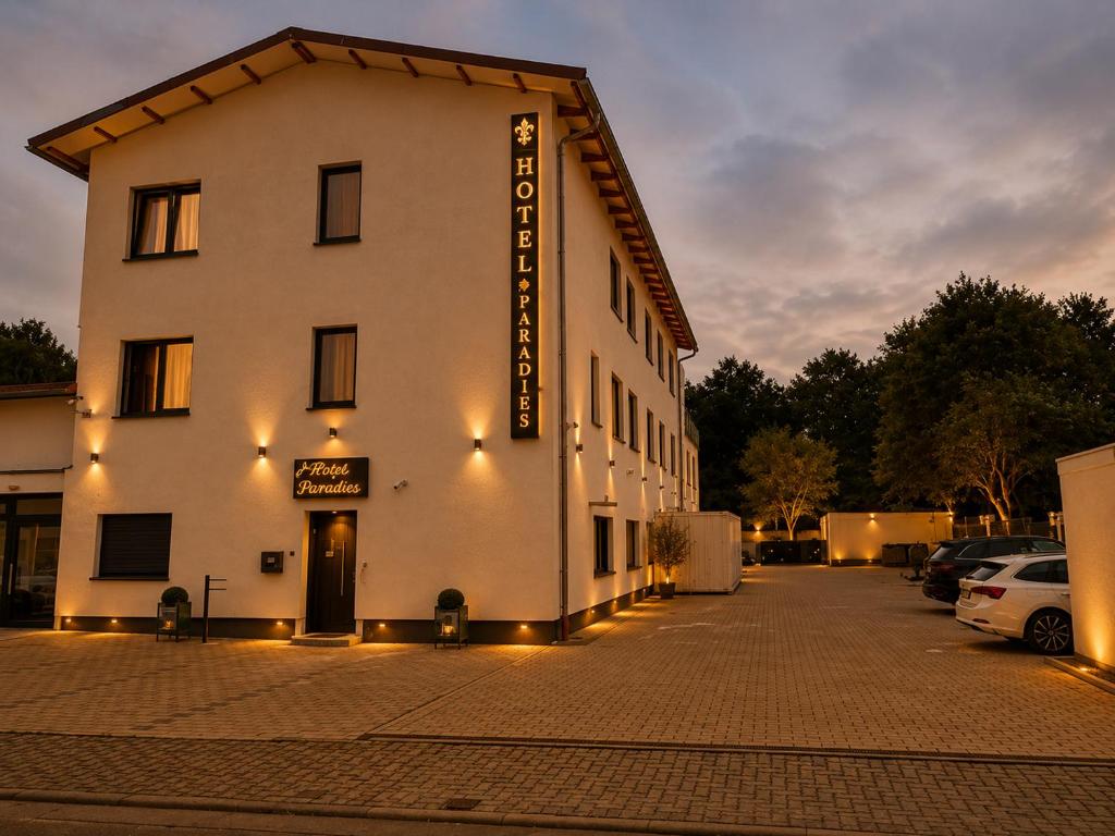 a white building with a sign on the side of it at Hotel Pasa Paradies KOSTENLOSE PARKPLÄTZE in Hanau am Main