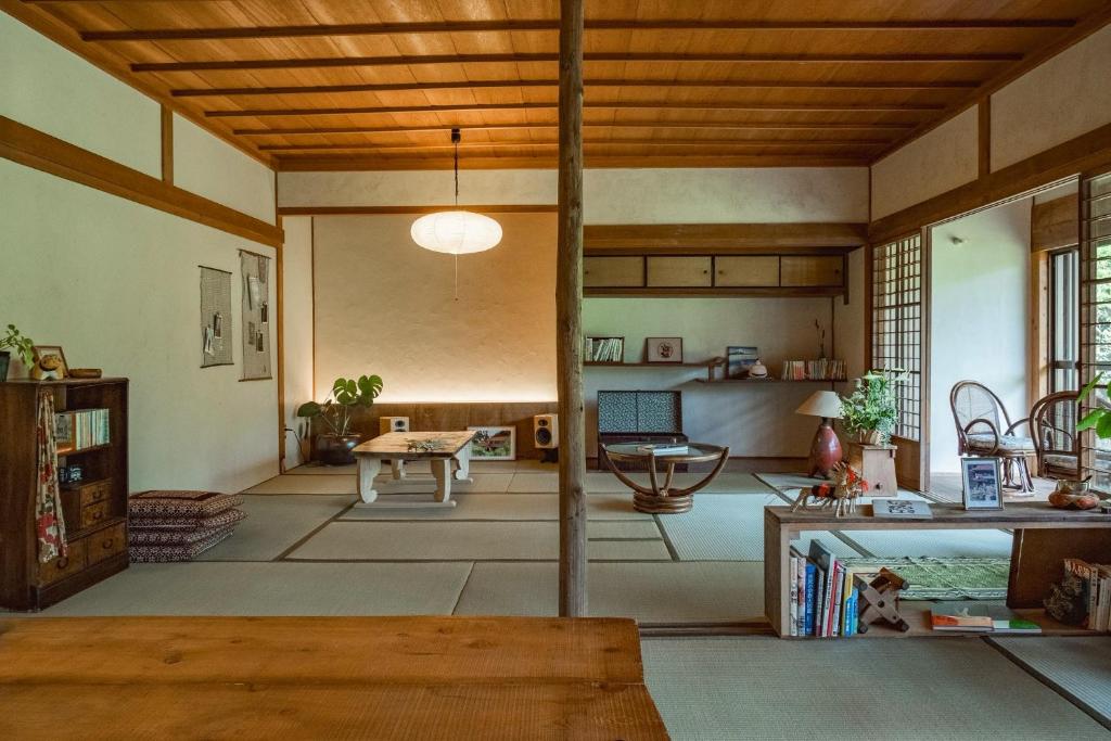 ein Wohnzimmer mit Holzdecke und einem Tisch in der Unterkunft guesthouse waku in Nagiso
