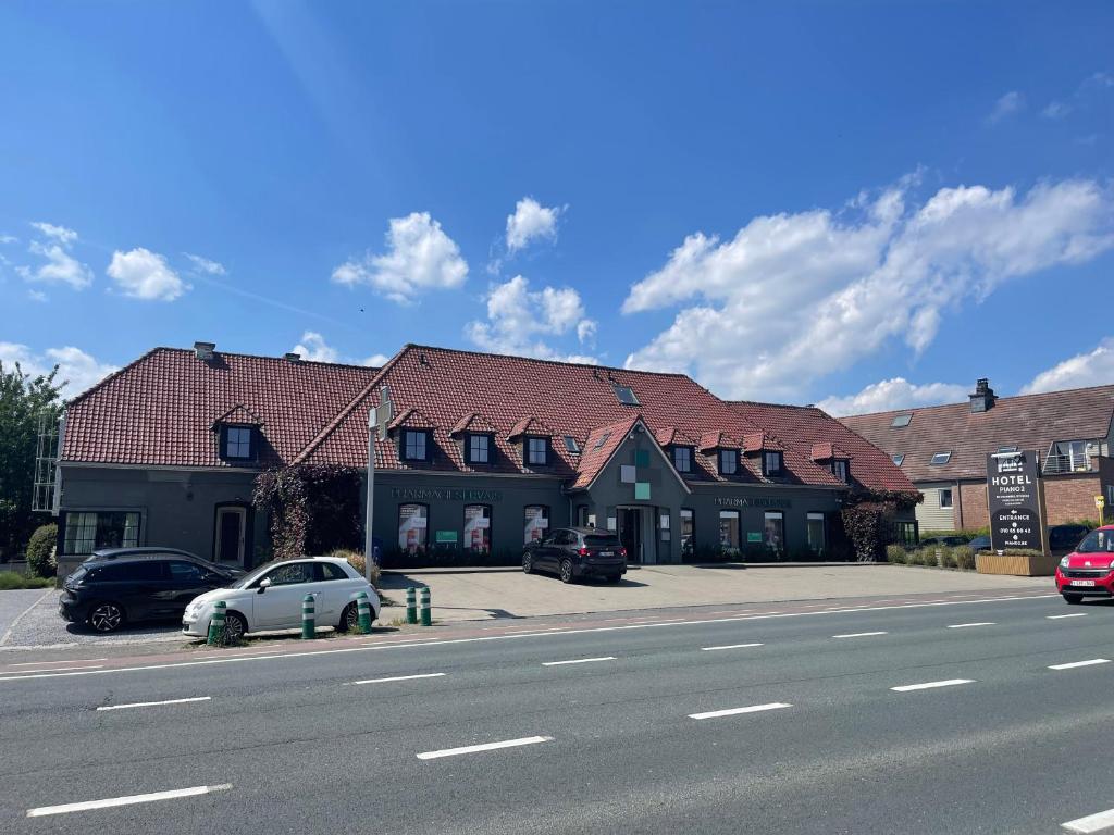 a building with cars parked on the side of a street at Hotel B&R Piano 2 - Louvain-la-Neuve - Mont Saint Guibert in Louvain-la-Neuve