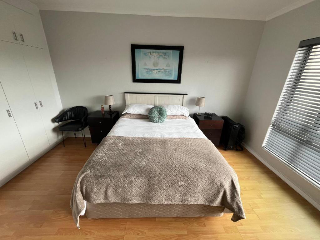 a bedroom with a bed and a chair in it at T&A Escape in Grassy Park
