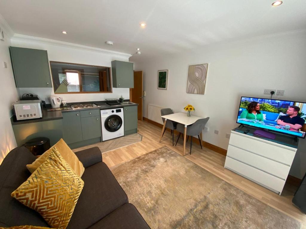 a living room with a couch and a flat screen tv at Apt 2 Cathedral & River view in Norwich