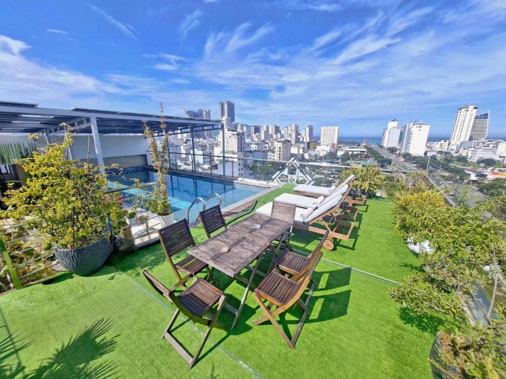 a table and chairs on the roof of a building at MiAn Hotel Danang - Infinity Pool in Danang