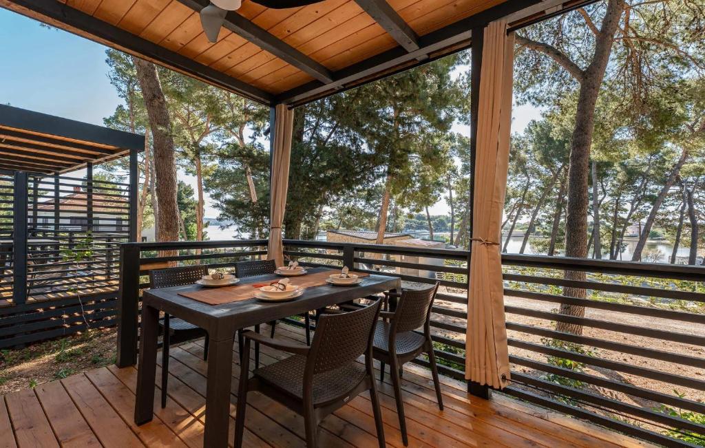 a wooden deck with a table and chairs on it at Luxury Homes Pašman in Pašman