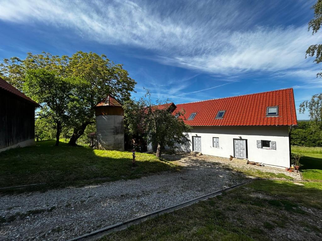 a white building with an orange roof and a barn at Barn House in Ptuj