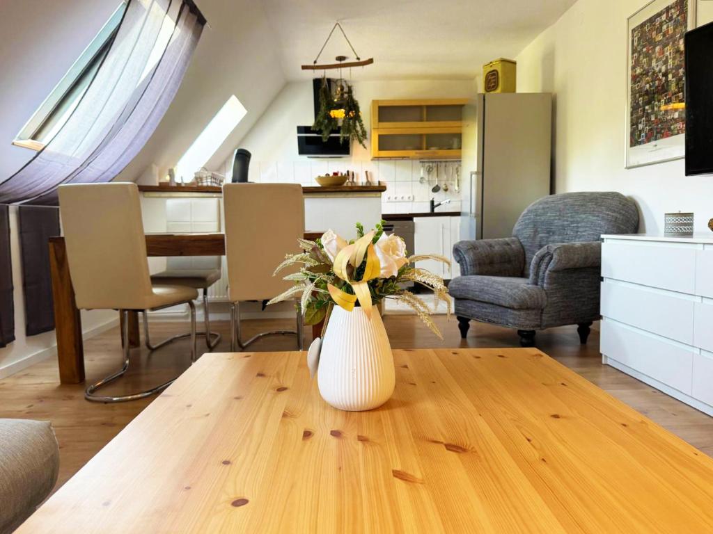 a vase with flowers on a wooden table in a living room at Ferienwohnung am Haff in Ueckermünde