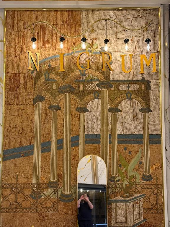 a person taking a picture of a wall with a mirror at Nigrum Hotel Nevsehir Cappadocia in Nevşehir