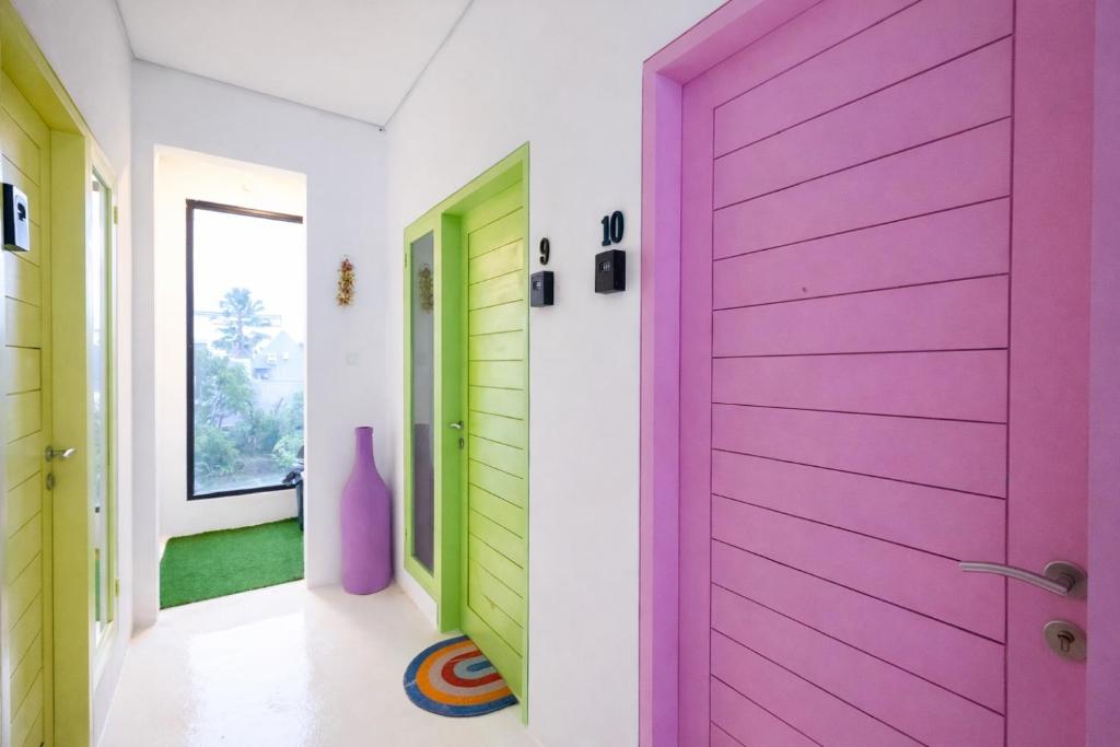a colorful door in a hallway with green and purple doors at Elia's House renovated in Canggu