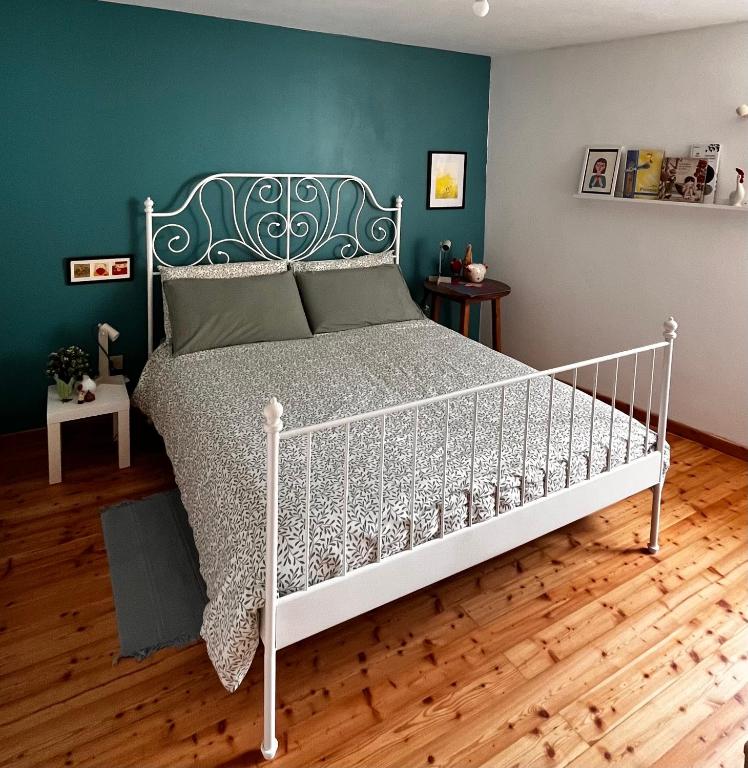 a white bed in a room with a green wall at Casa Stella in Venzone