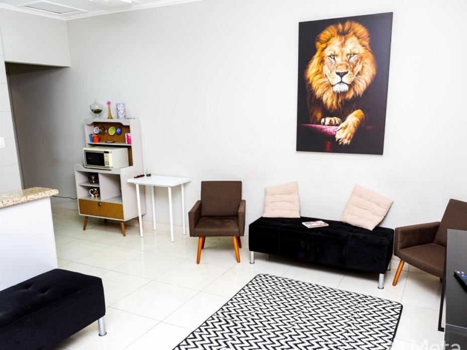 a living room with a lion painting on the wall at Casa aconchegante centro in Peruíbe