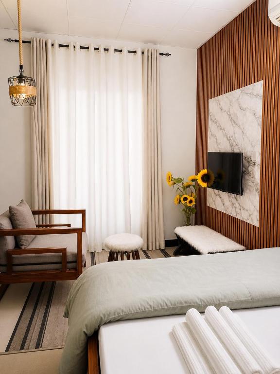 a bedroom with a bed and a living room at 1BDM Aptmt Free Wifi,TV, NETFLIX,FRIDGE,KITCHEN-busy area in Dar es Salaam