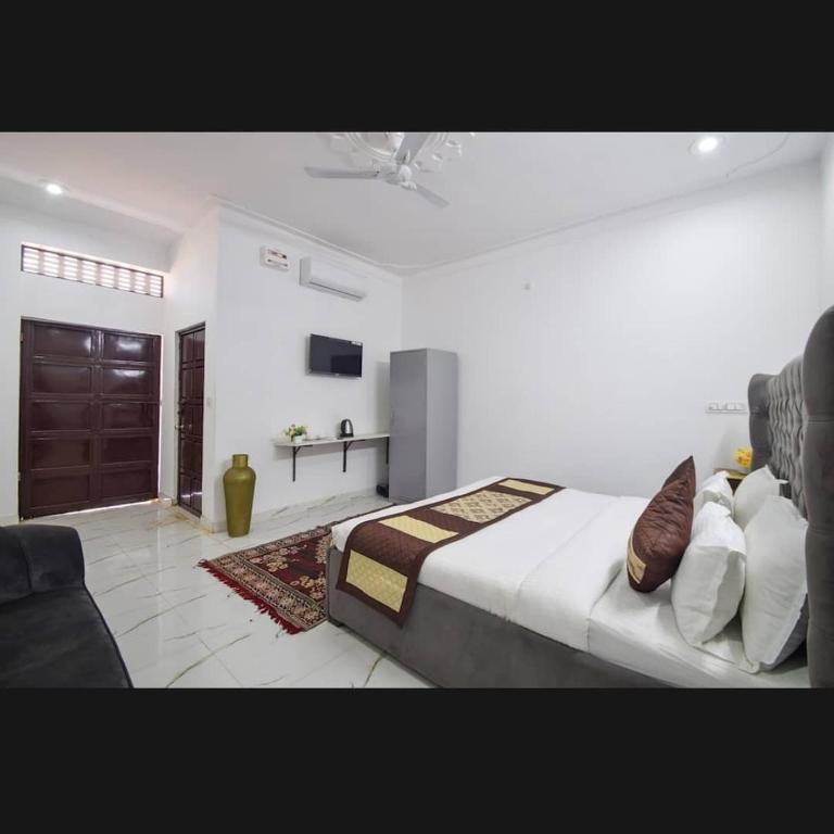 a bedroom with a large bed and a tv at The Udaikot farm in Rāma
