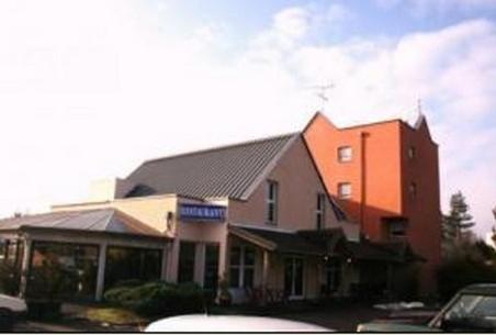 a group of buildings with cars parked in a parking lot at Kyriad Direct Lure in Lure