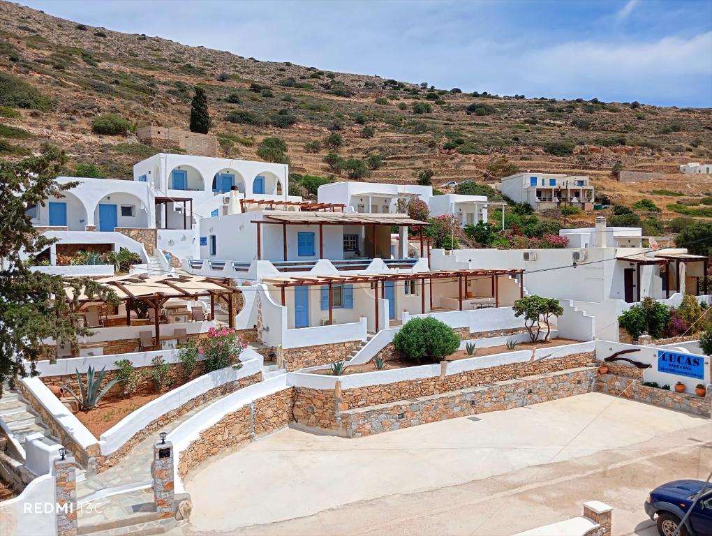 a group of white houses with a hill in the background at Lucas B Panorama in Sikinos