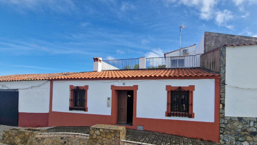 a white and red house with a balcony on top at AT El Cordel in Nogales