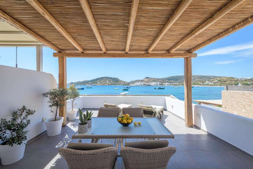 a patio with a table and chairs and the ocean at Michalakis Seaside Suites in Pollonia