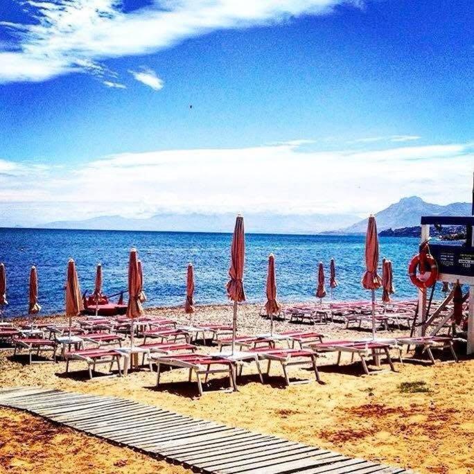 a group of beach chairs and umbrellas on a beach at Casa Vacanza Colletta - appartamenti e lido in Casteldaccia