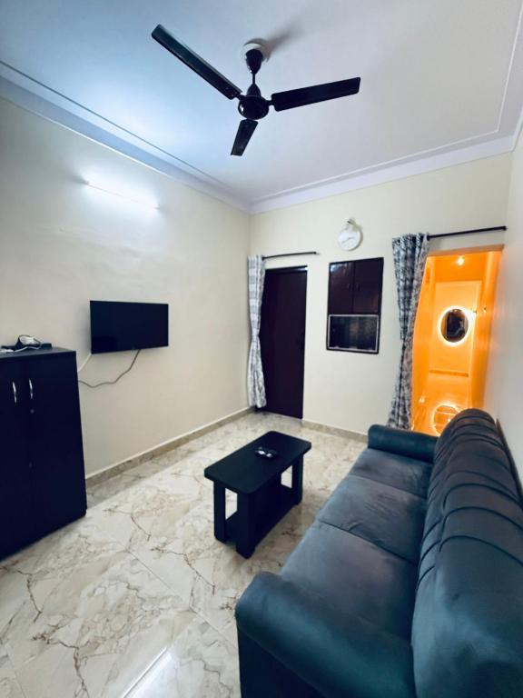 a living room with a couch and a ceiling fan at Wee Homes in Bangalore
