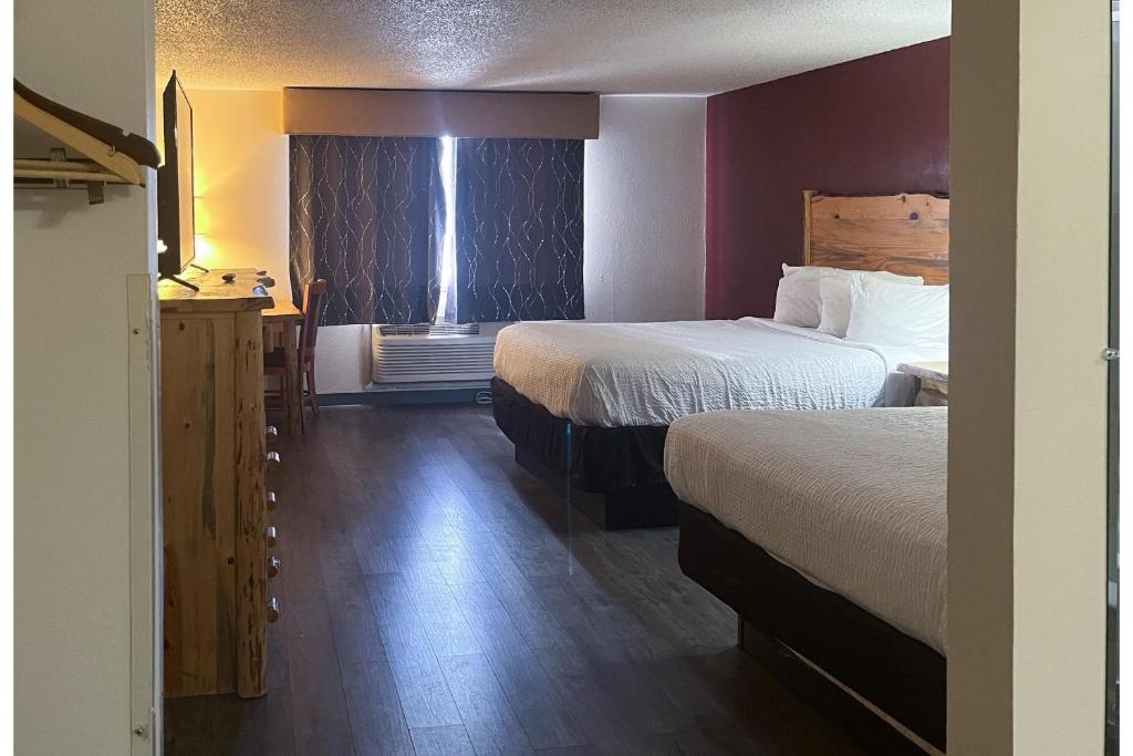 a hotel room with two beds and a window at Studio 6 Suites Butte MT I-90 I-15 in Butte