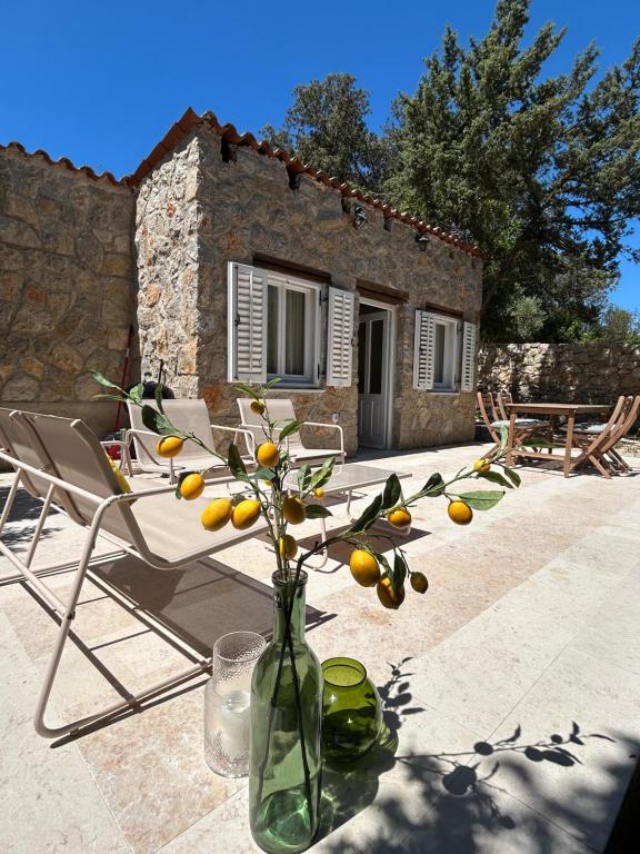 a table with a vase with flowers in front of a house at Stone house Vert in Sveti Jakov