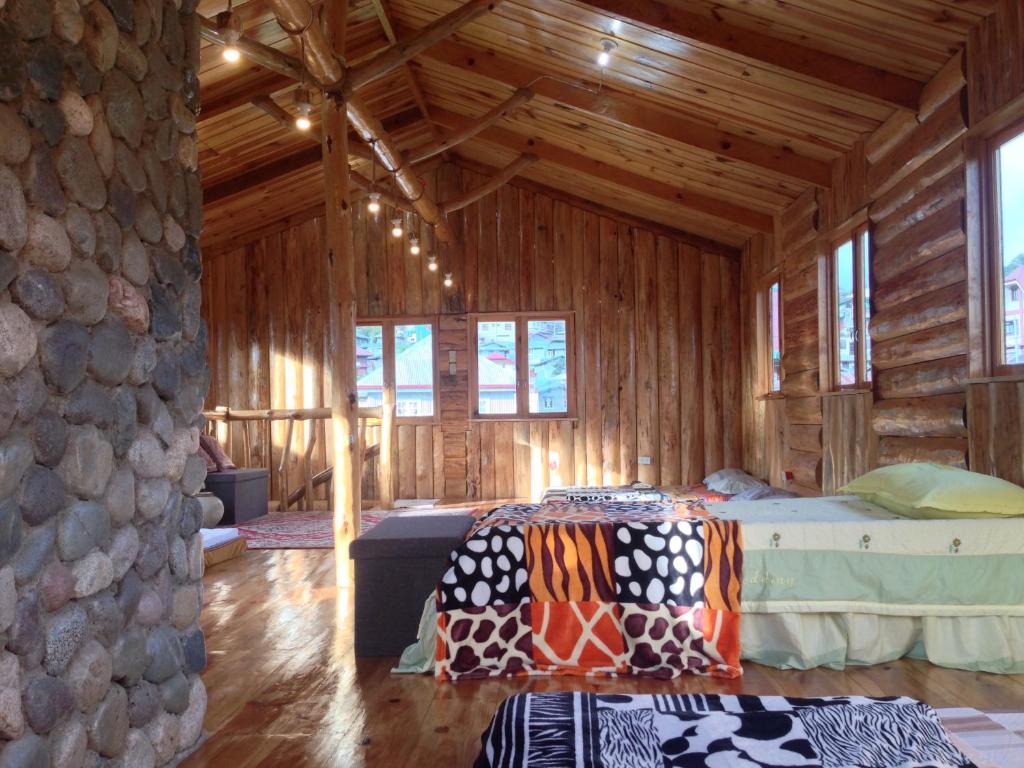 Habitación con cama en una cabaña de madera en Agape Log Cabin, en Sagada