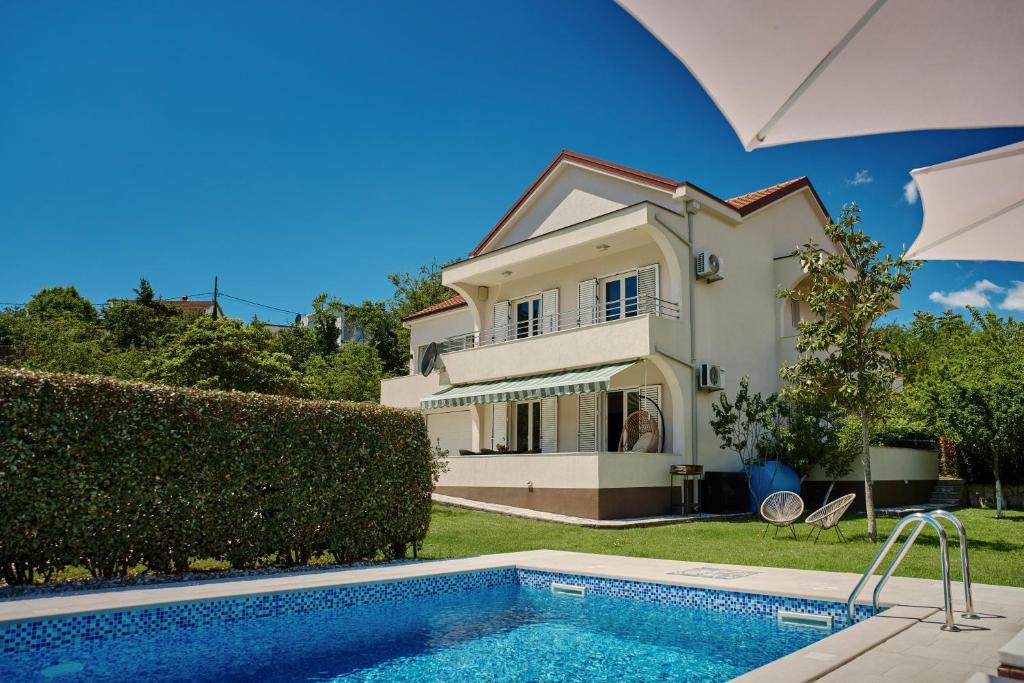 a villa with a swimming pool in front of a house at Villa MontAnja in Herceg-Novi