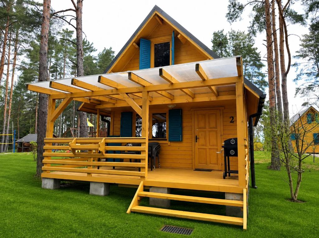 a small house with a roof on the grass at Nartówka in Narty